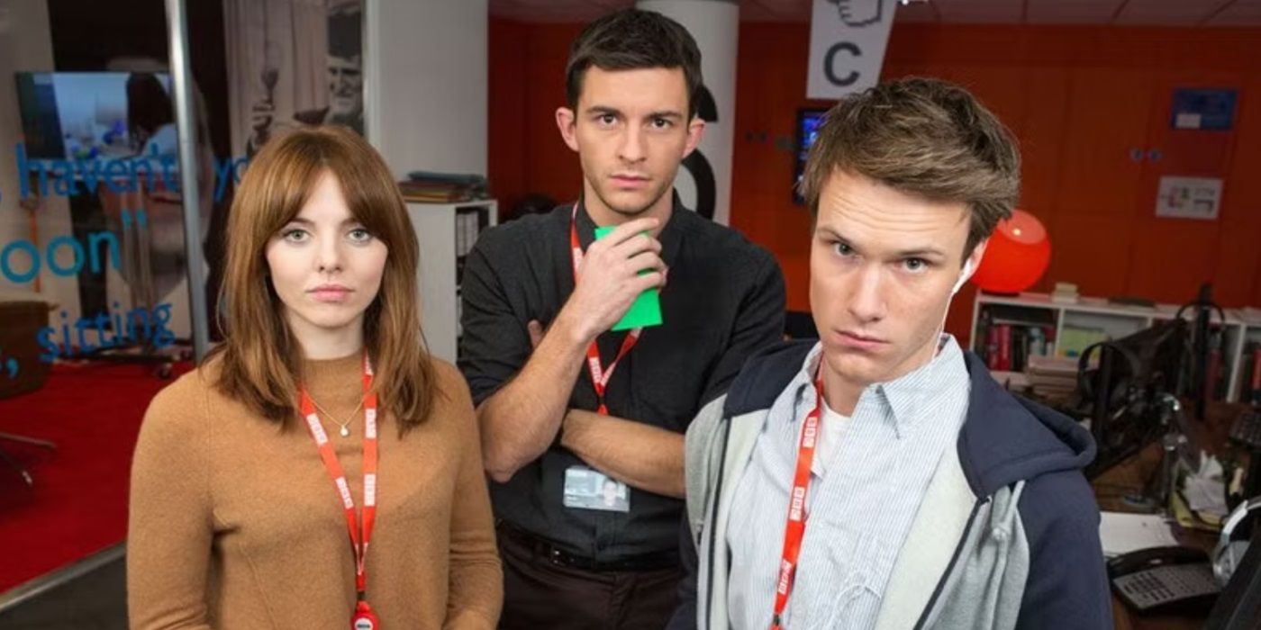 Jonathan Bailey and two costars wear badges around their necks and look at the camera in W1A.