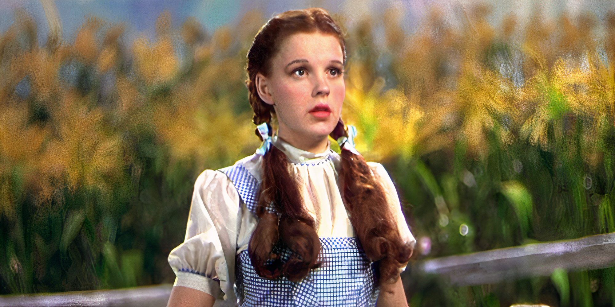 Judy Garland as Dorothy Gale, standing in front of yellow flowers and looking surprised in The Wizard of Oz