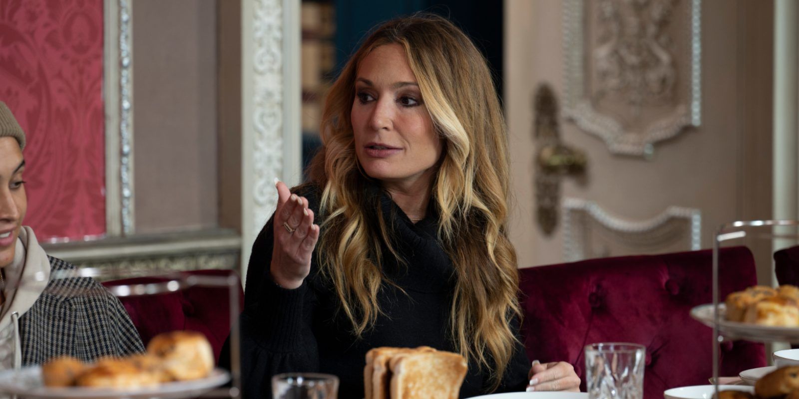 Kate Chastain talks at a fancy dinner table in The Traitors.