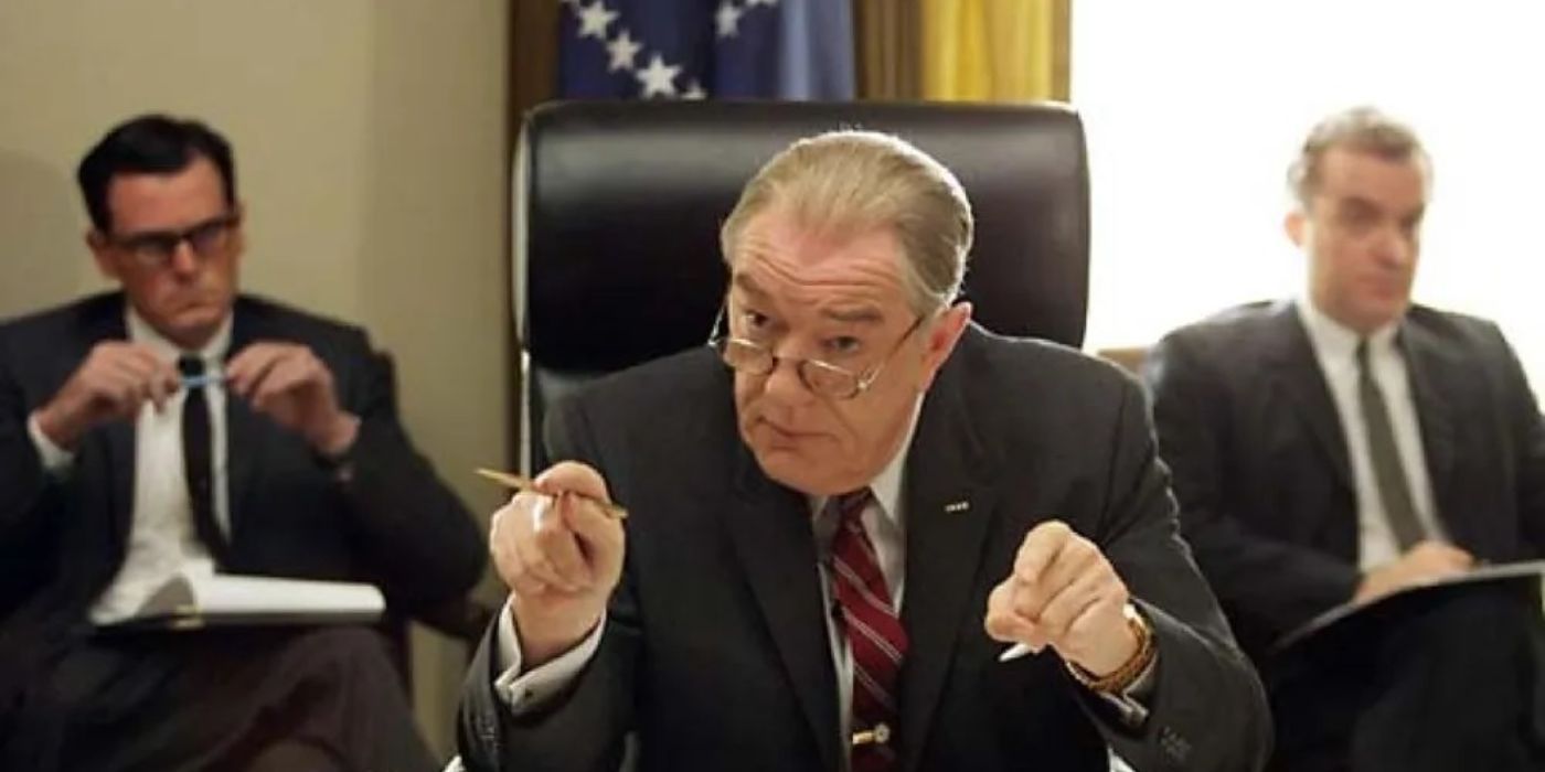 Michael Gambon as Lyndon Johnson sits in a government room with officials in Path to War.