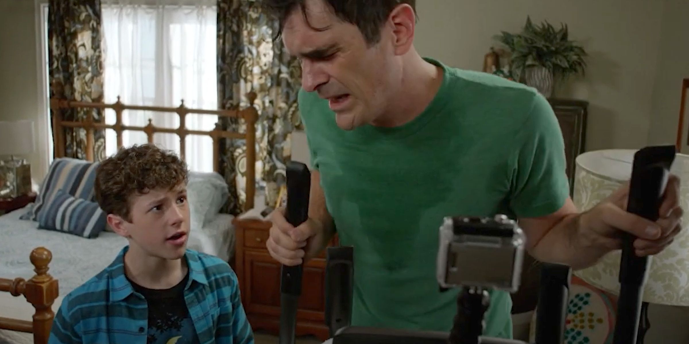 Luke (Nolan Gould) encouraging Phil (Ty Burrell) on an elliptical machine in Modern Family