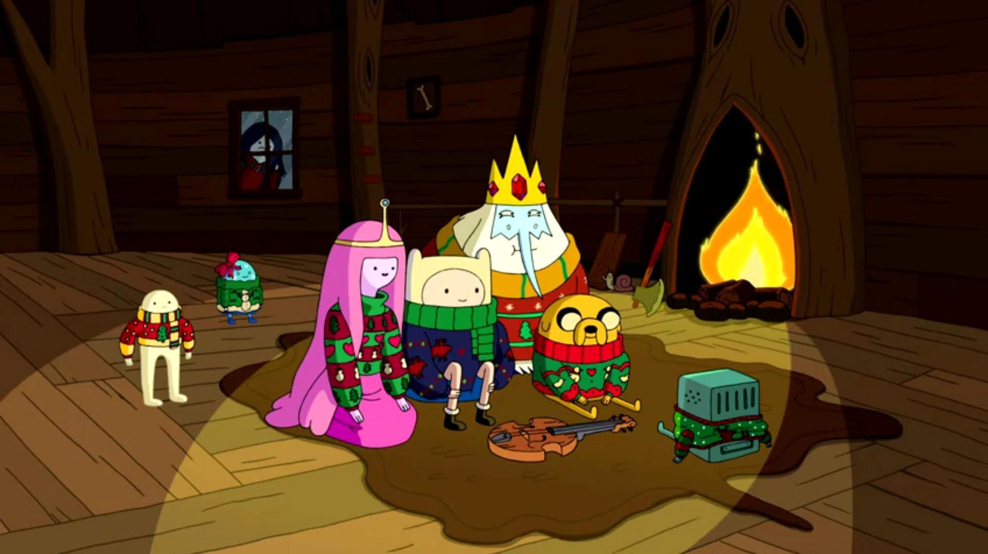 The cast sit with a fireplace in the background and watches TV