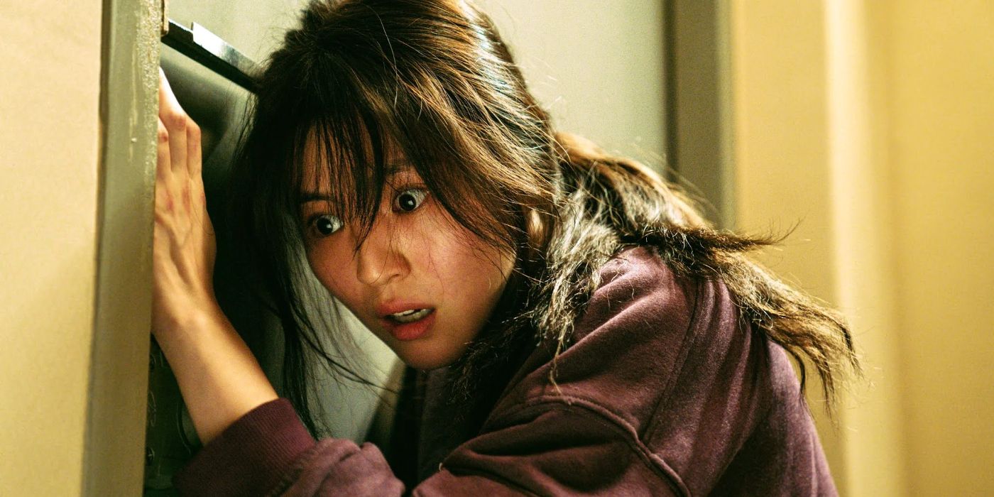Ji-woo (Han So-hee) standing against a door with a terrified and shocked expression in My Name.