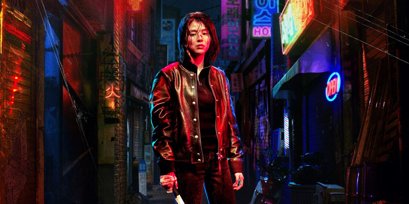 Ji-woo (Han So-hee) standng in the city streets, wearing a black leather jacket, and holding knife in her left hand in My Name