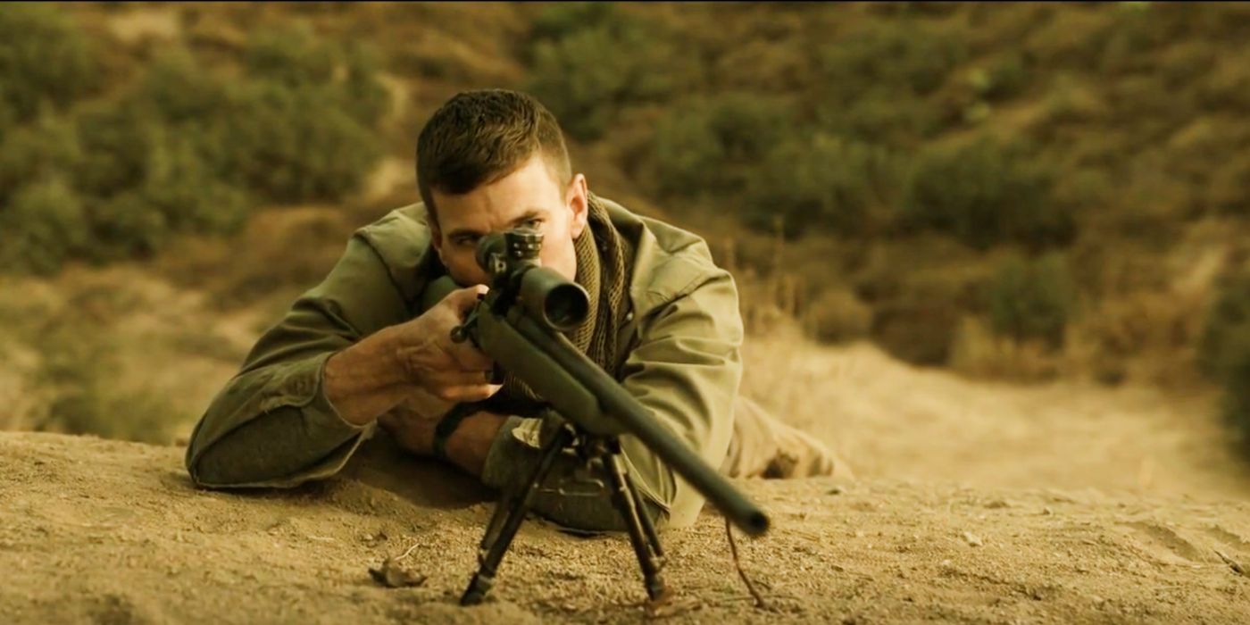 Leroy Jethro Gibbs lying down on his front looking down a sniper scope in NCIS: Origins