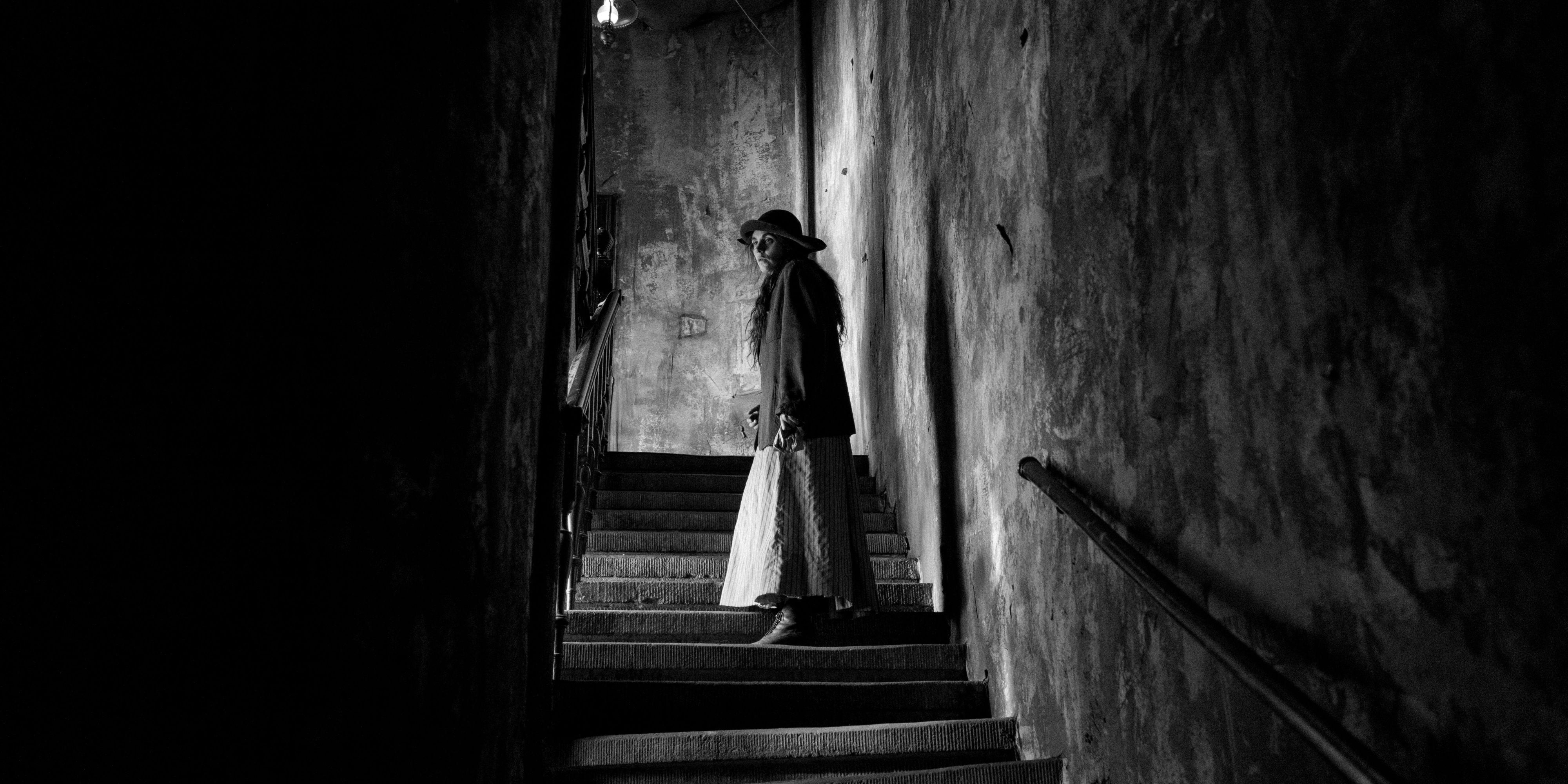 Karoline, played by actor Vic Carmen Sonne, stands on an empty stairwell in The Girl With The Needle