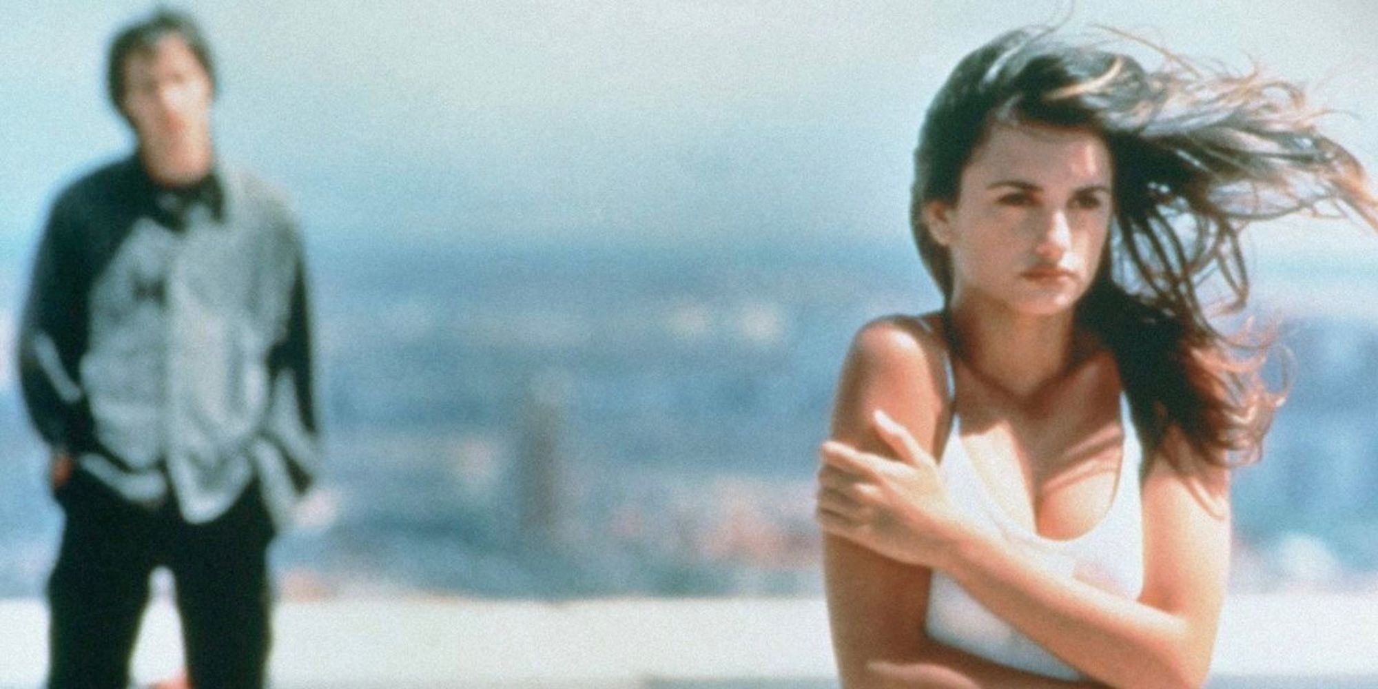 Penelope Cruz on a rooftop with a man standing in the distance behind her in Open Your Eyes (1997)