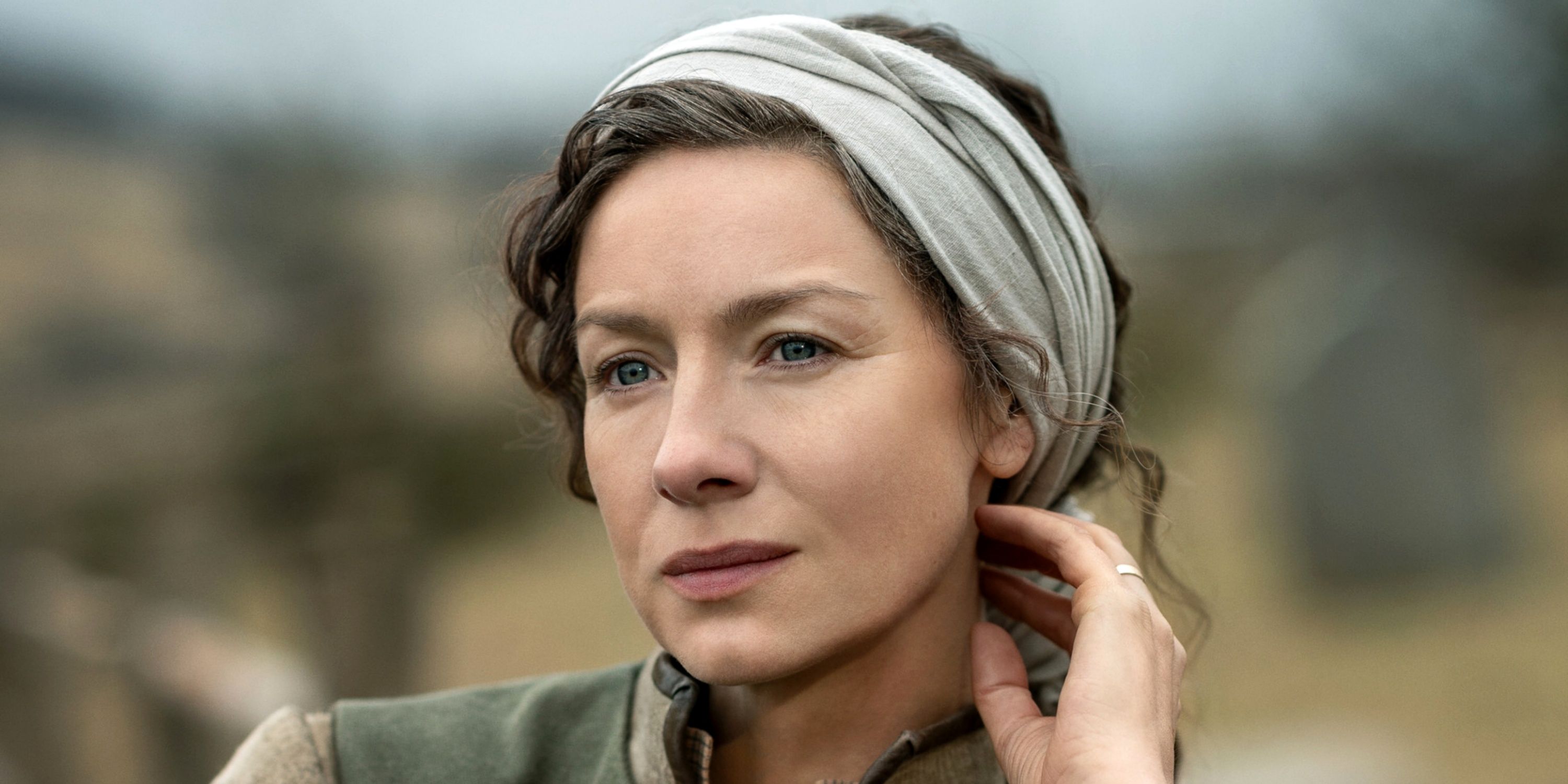 Caitriona Balfe as Claire looking off to the right with her left hand on her neck in Season 7 Pt 2 of Outlander