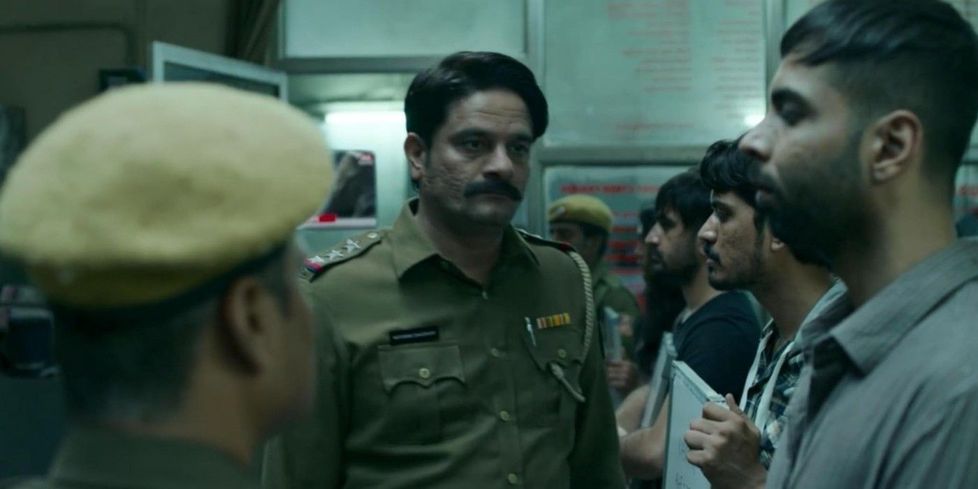 A uniformed officer walks through a crowd solemnly in Paatel Lok on Prime Video