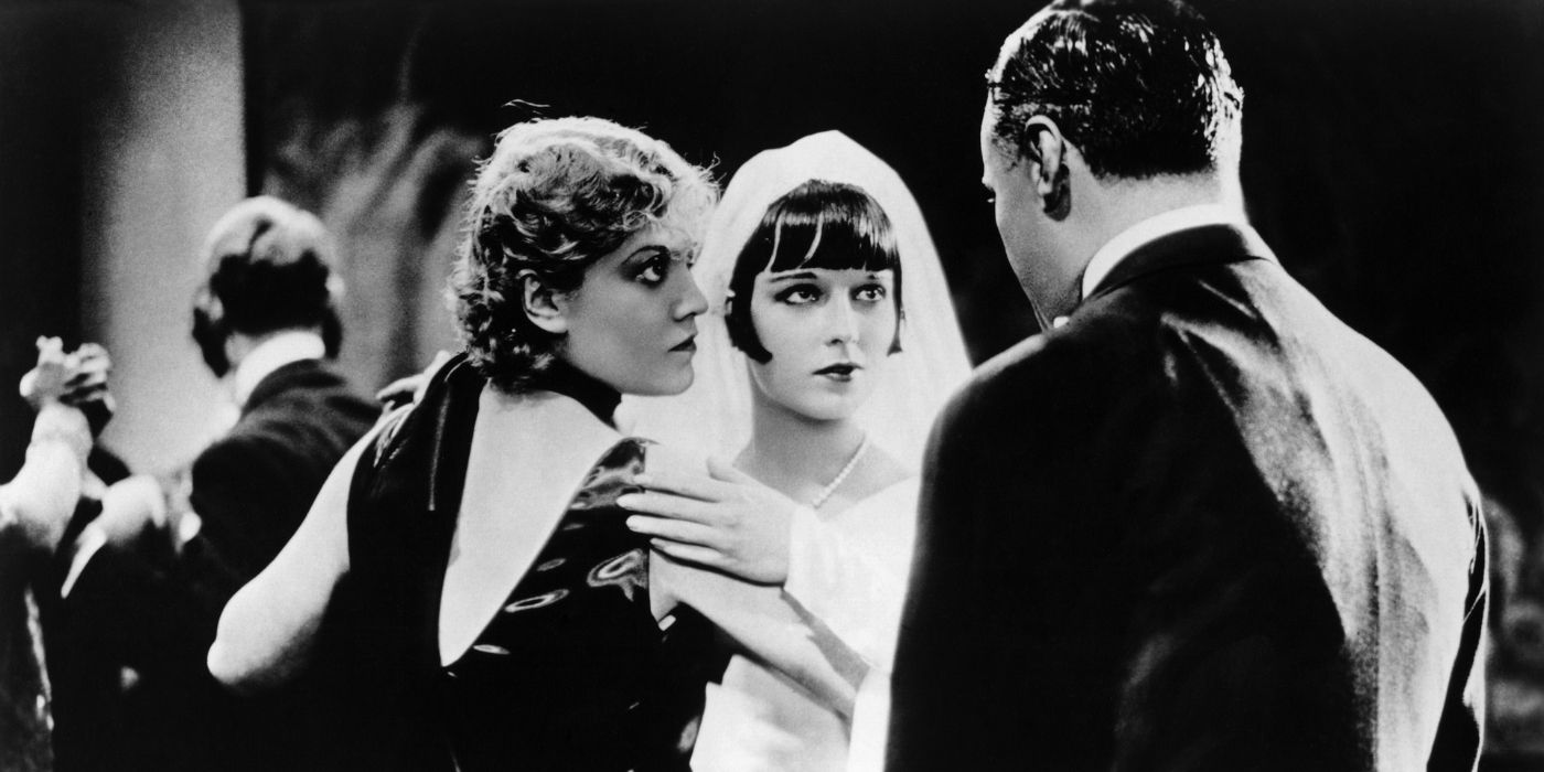 Two women dancing while looking at a man in Pandora&rsquo;s Box