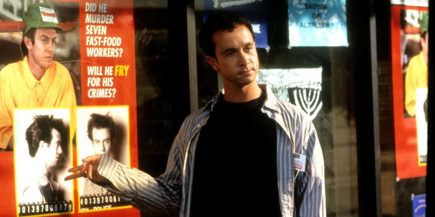 Pauly Shore pointing to a poster with a mugshot in Jury Duty