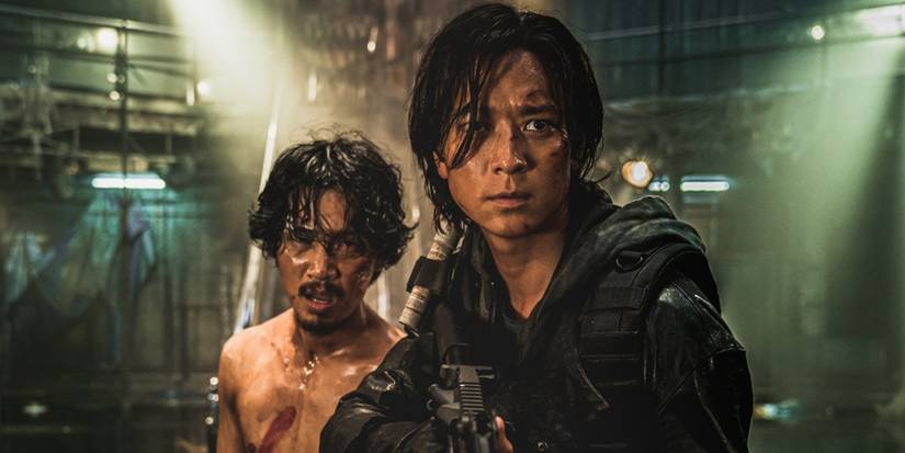 Kim Do-yoon with no shirt standing behind Gang Dong-won  in tactical gear and holding a gun in "Train to Busan: Peninsula"