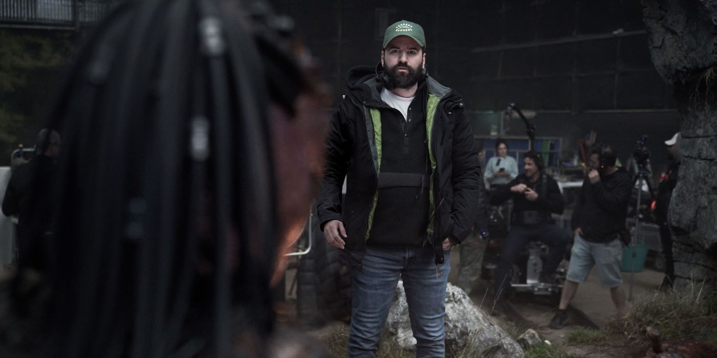 Dan Trachtenberg looking at a Predator on the set of Predator: Badlands.