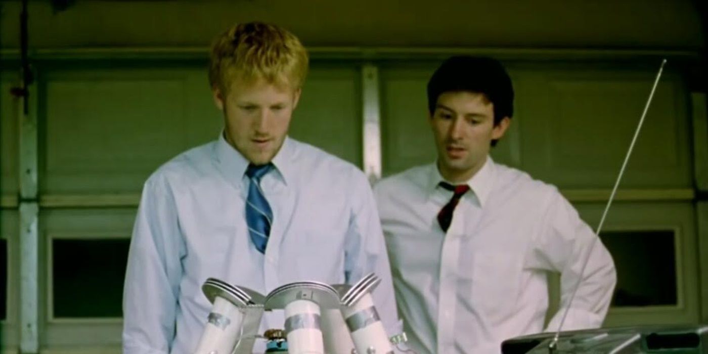 Shane Carruth as Aaron and David Sullivan as Abe looking at a machine in Primer