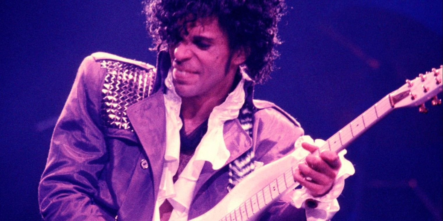 Prince playing guitar on stage in Purple Rain