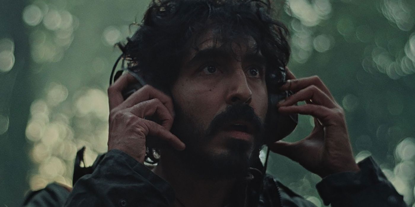 Dev Patel with his hands on his headset in Rabbit Trap