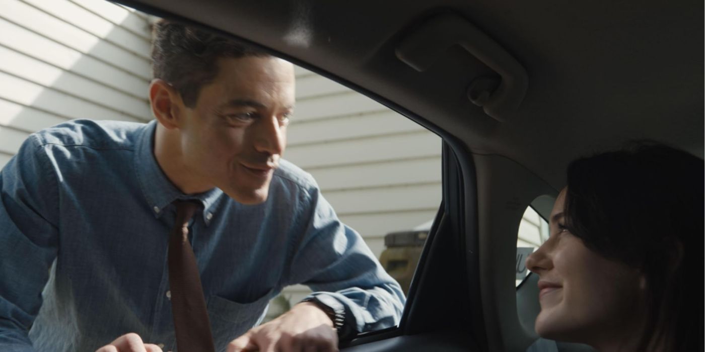 Rami Malek standing next to a car window and looking at Rachel Brosnahan in &lsquo;The Amateur&rsquo;.