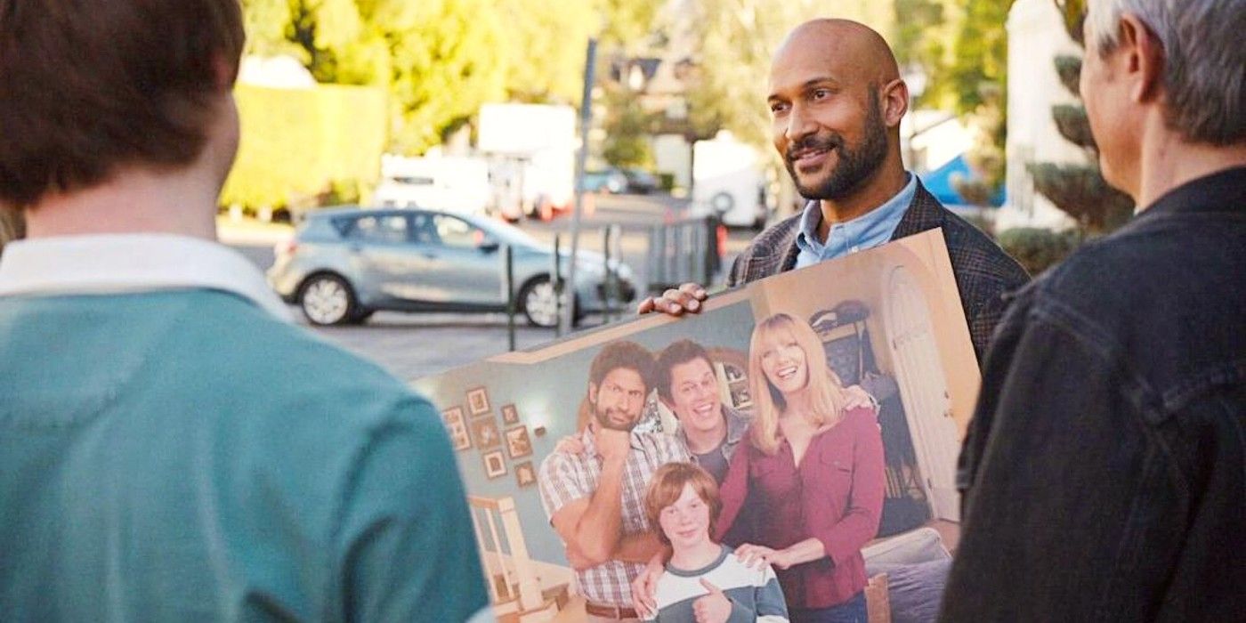 Reed holding a picture of the original Step Right Up cast in Reboot.