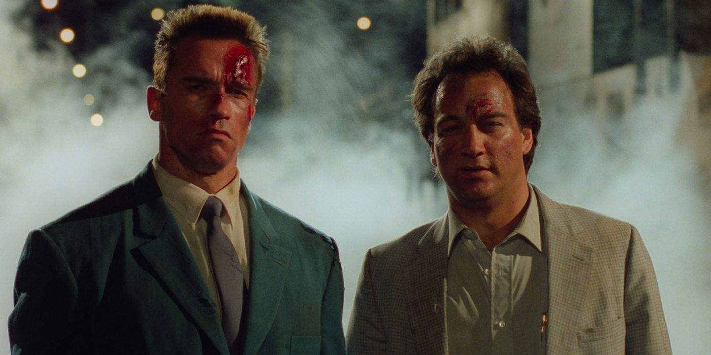 Arnold Schwarzenegger and Jim Belushi stare into the distance with smoke behind them in Red Heat.