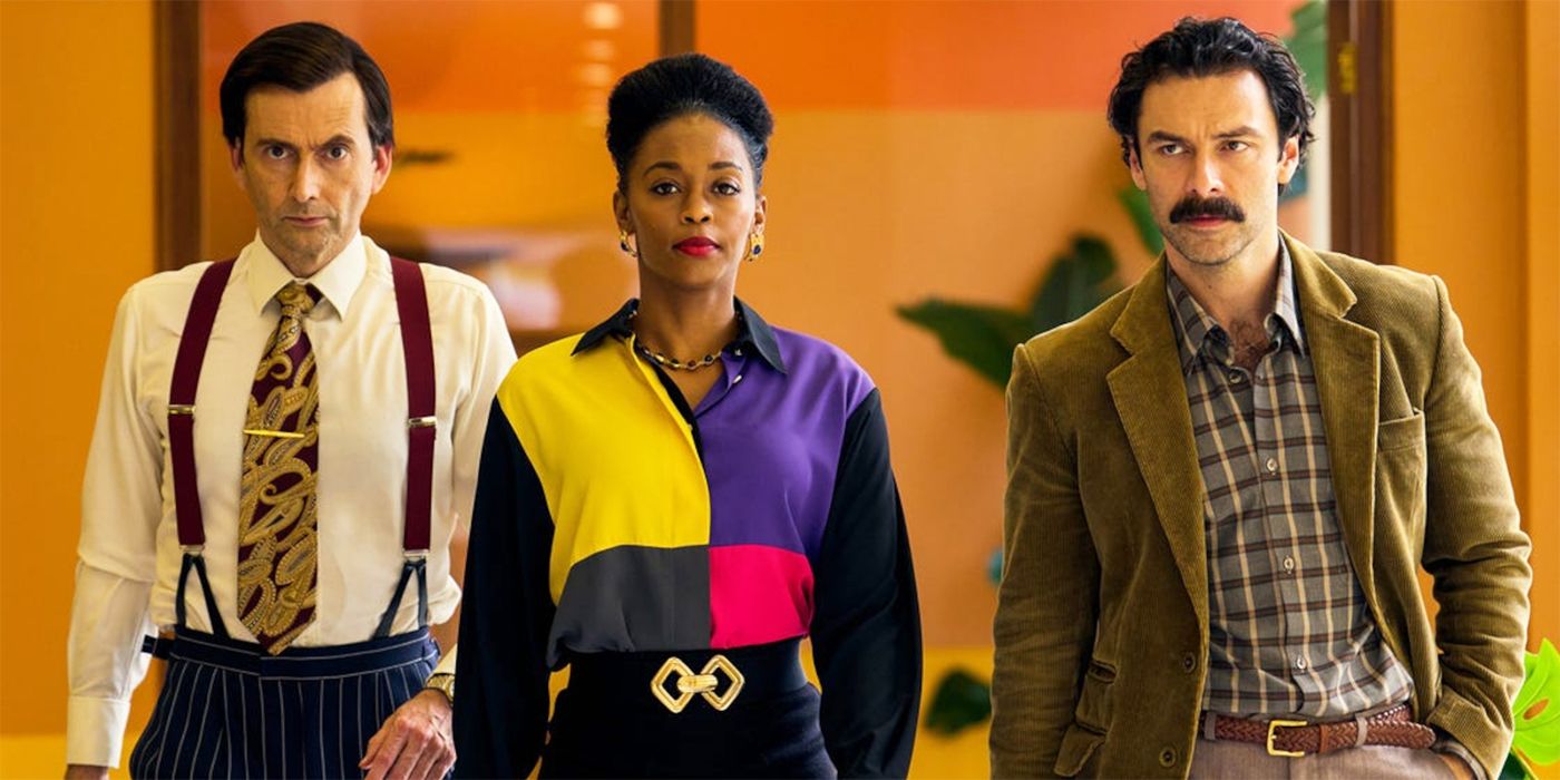 David Tennant, Nafessa Williams, and Aidan Turner walking together through the halls of Corinium in Rivals