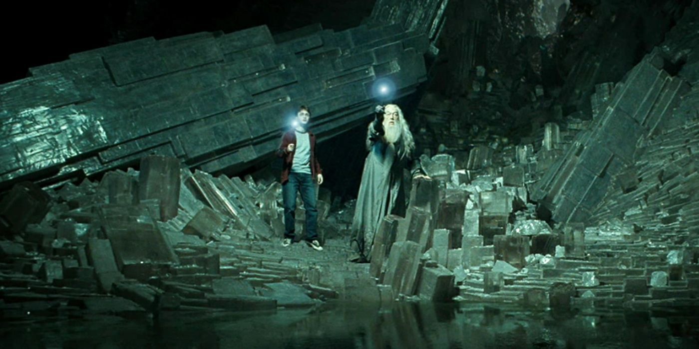 Dumbledore and Harry shine lights from their wands in a dark cave in Harry Potter and the Half-Blood Prince.