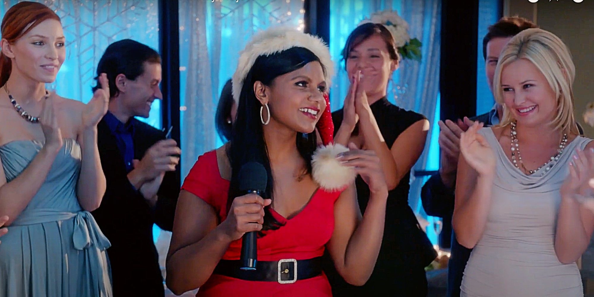 Mindy Lahiri dressed in a Santa outfit surrounded by imaginary party guests in The Mindy Project.