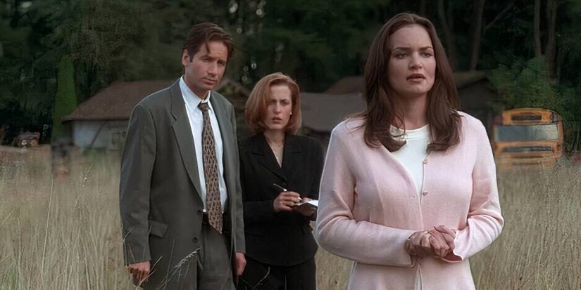 David Duchovny as Fox Mulder, Gillian Anderson as Dana Scully and Kristen Cloke as Melissa standing in a field in 'The X-Files'