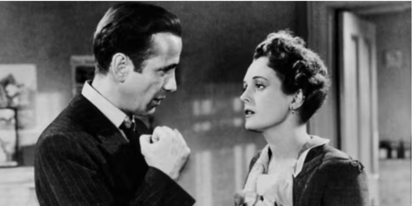 Sam Spade and Mary Astor as Sam Spade and Ruth wearing a black suit and white blouse in &lsquo;The Maltese Falcon&rsquo;