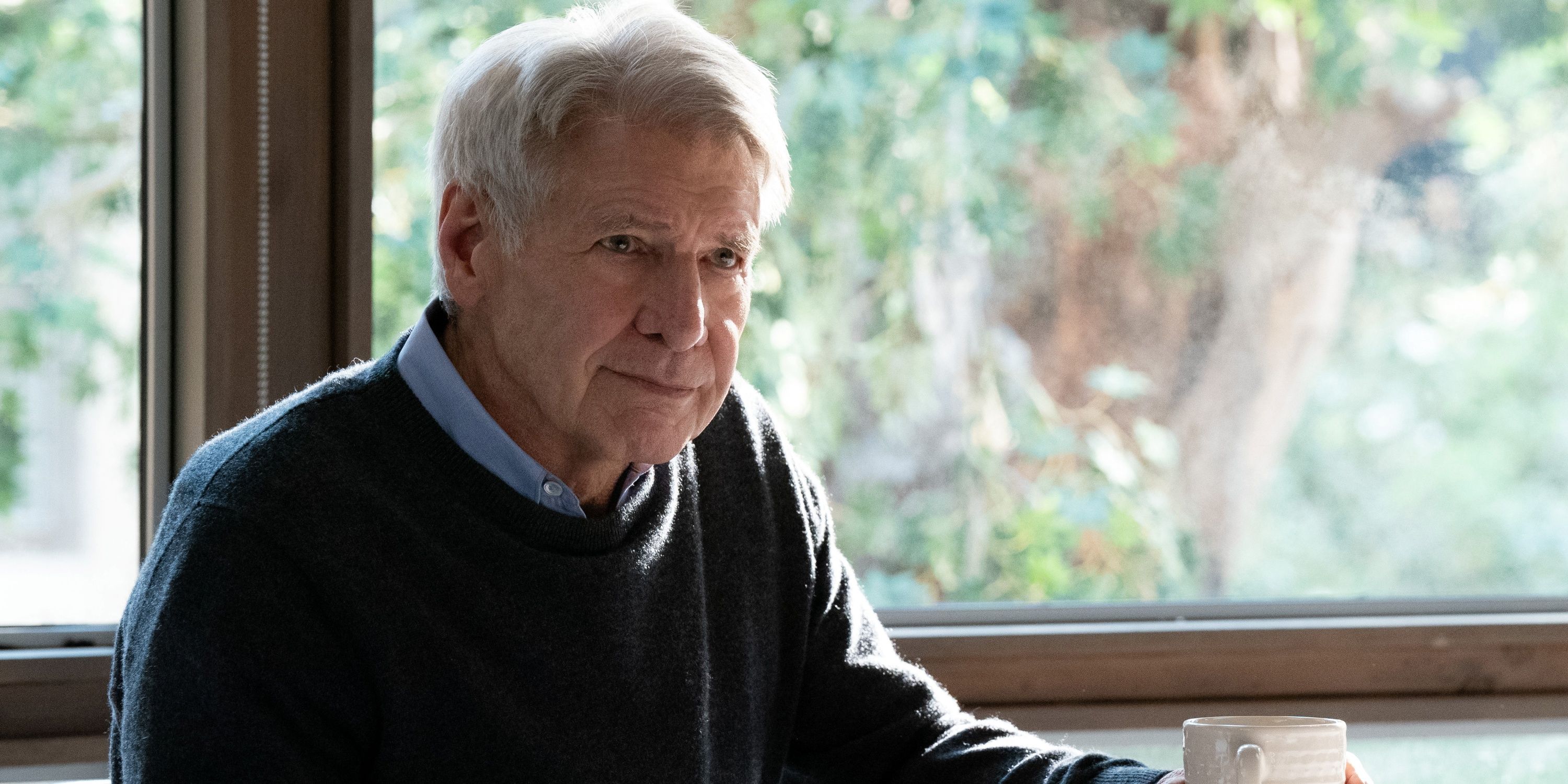 Harrison Ford as Paul sitting at the table with a cup of coffee in his hand in Season 2 of Shrinking