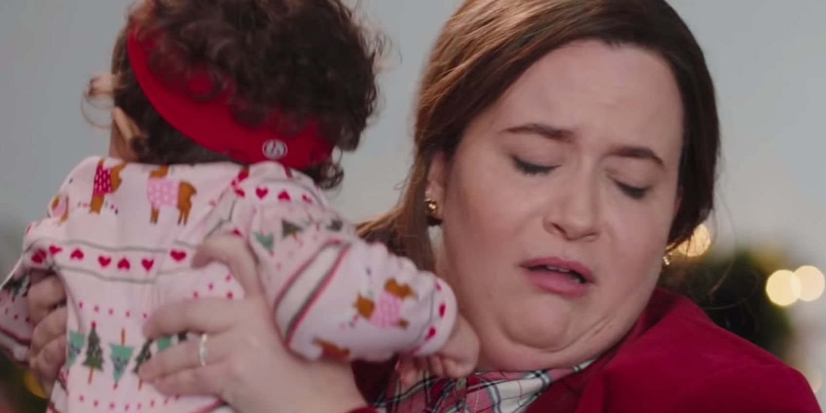 Aidy Bryant holding a baby and turning in disgust in the Saturday Night Live skit Children's Clothing Ad.