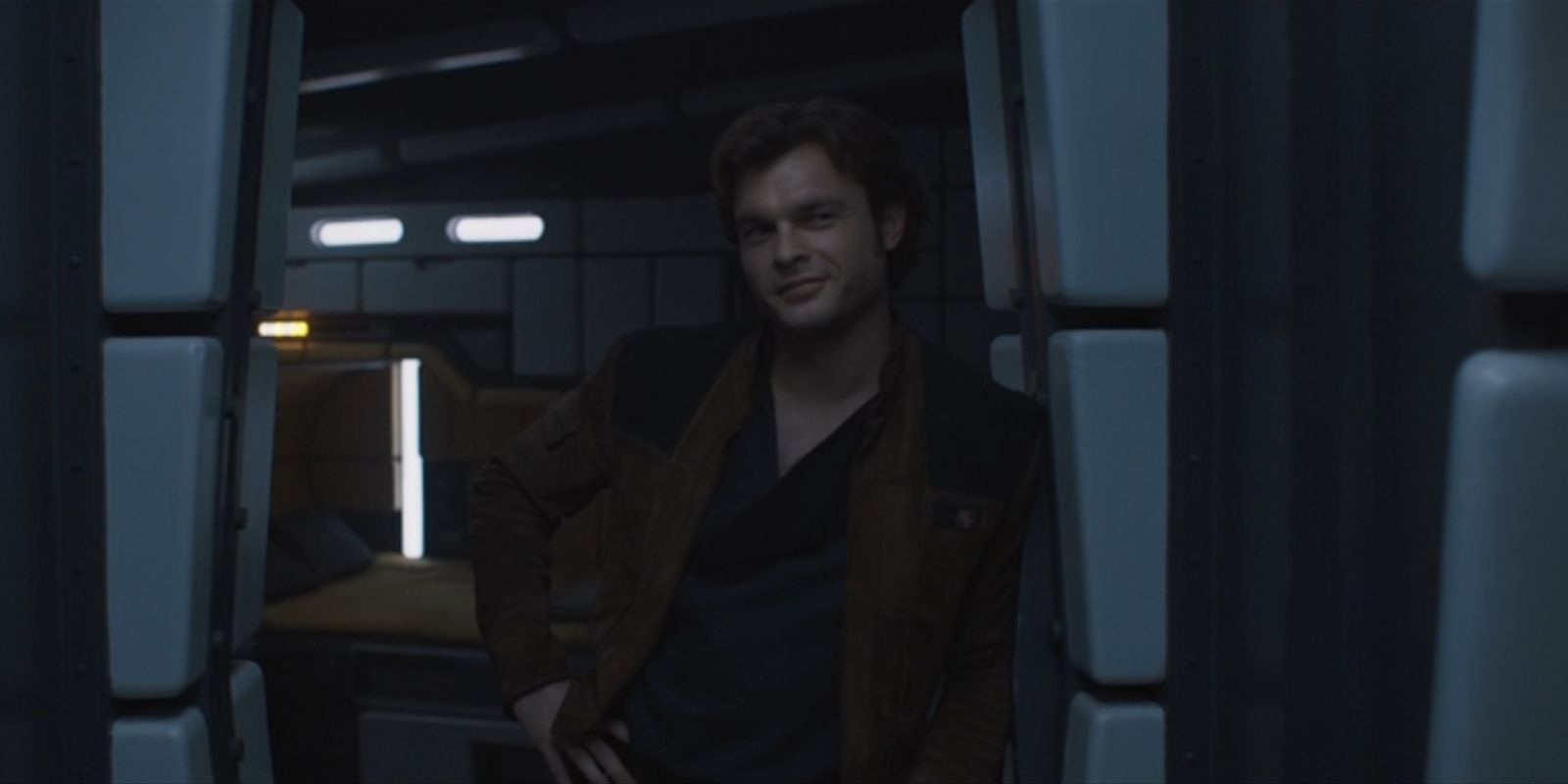 Han Solo, played by Alden Ehrenreich, smirks while standing in a doorway in 'Solo: A Star Wars Story'.