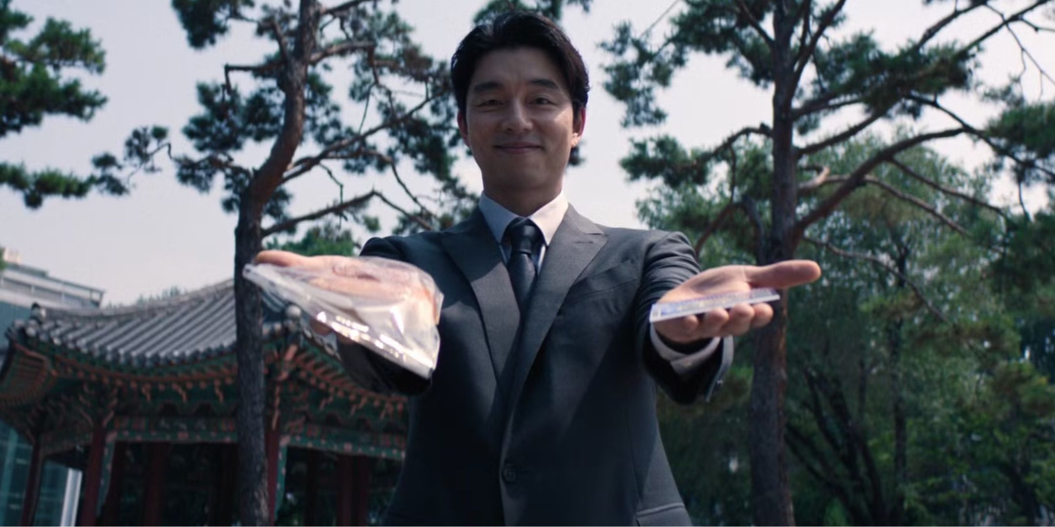 Gong Yoo as the Salesman holding bread and lottery ticket in Squid Game Season 2.