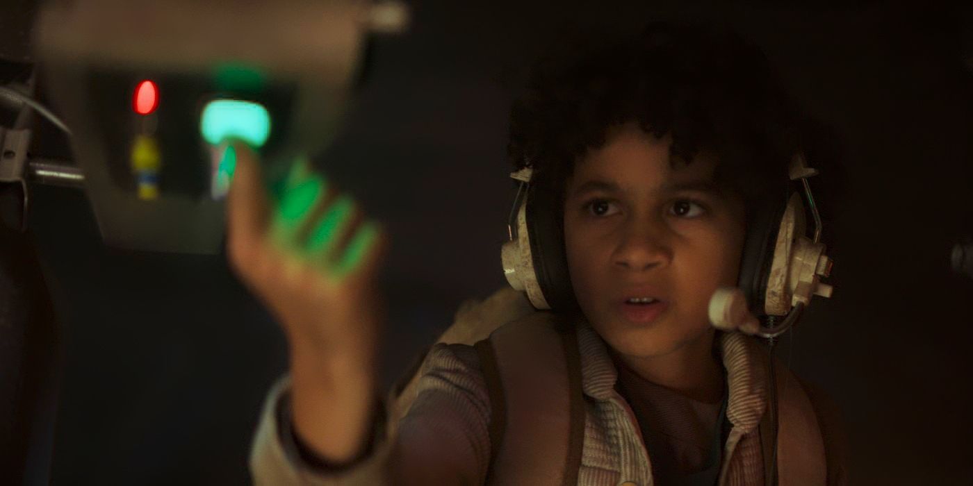 Ravi Cabot-Conyers pushing a blinking green button in Star Wars: Skeleton Crew Episode 1