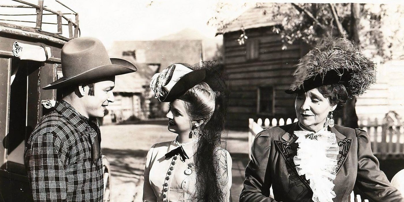  Roy Rodgers in a cowboy hat talks to two women in vintage dresses in a western town in Sunset in El Dorado.