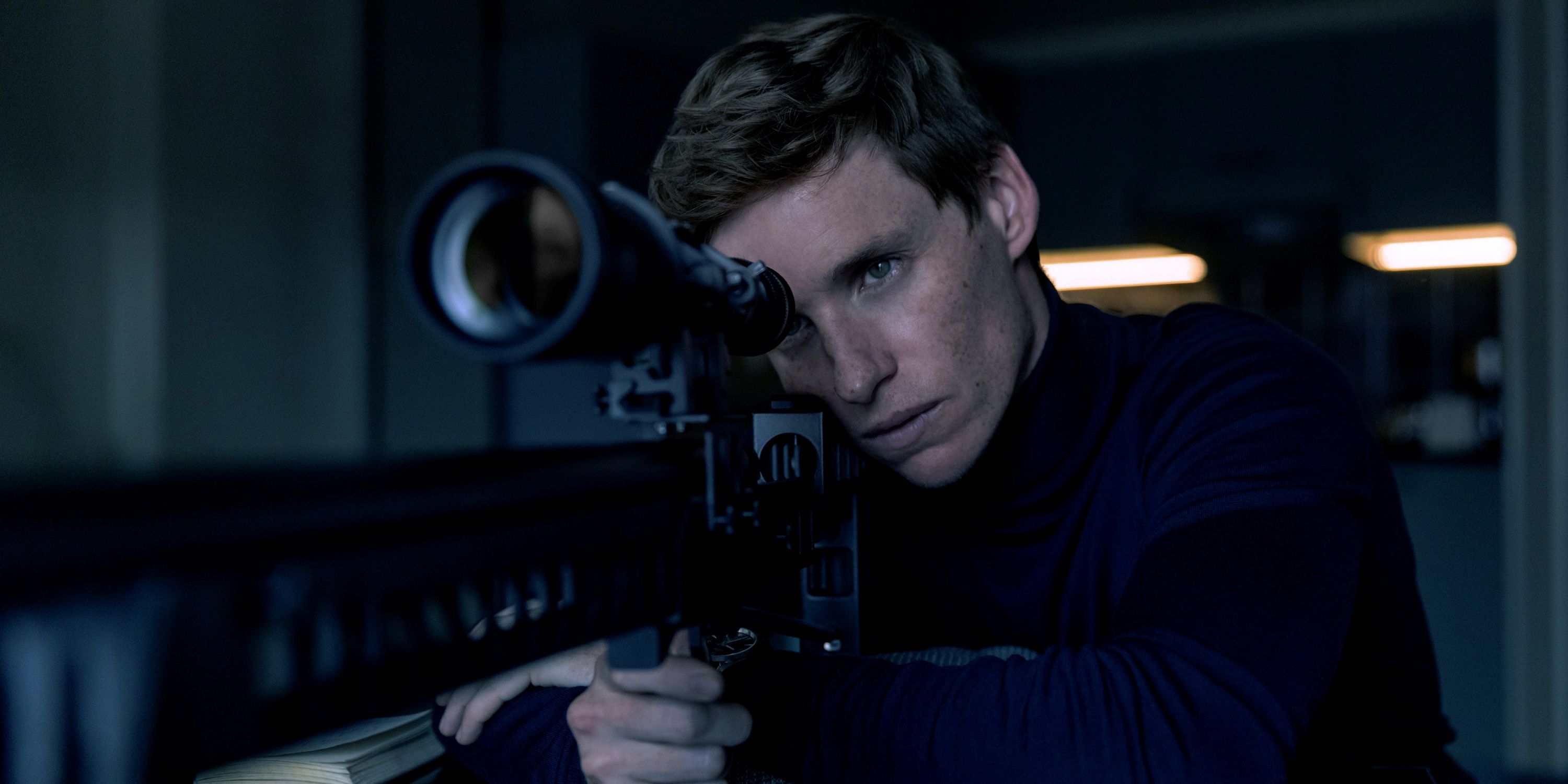 Eddie Redmayne as The Jackal waiting to shoot a sniper rifle in The Day of the Jackal