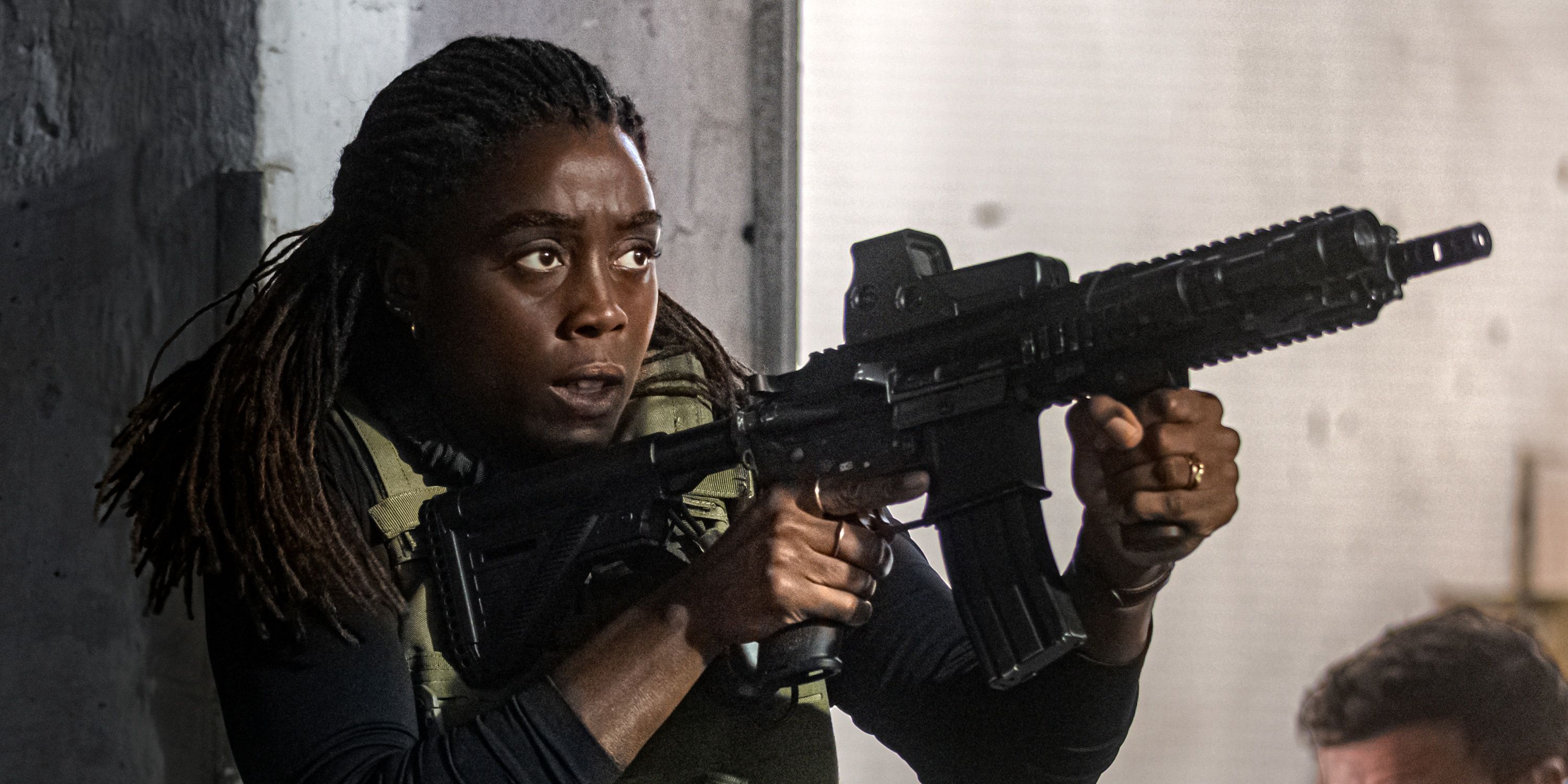 Lashana Lynch as Bianca Pullman ready to shoot an automatic weapon in The Day of the Jackal