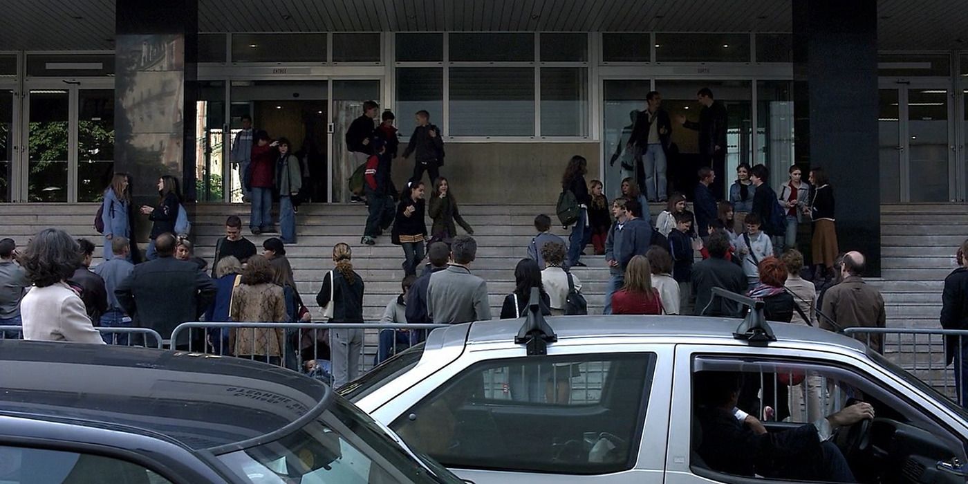 A crowd gathered outside a school at the end of the day in Caché (2005).