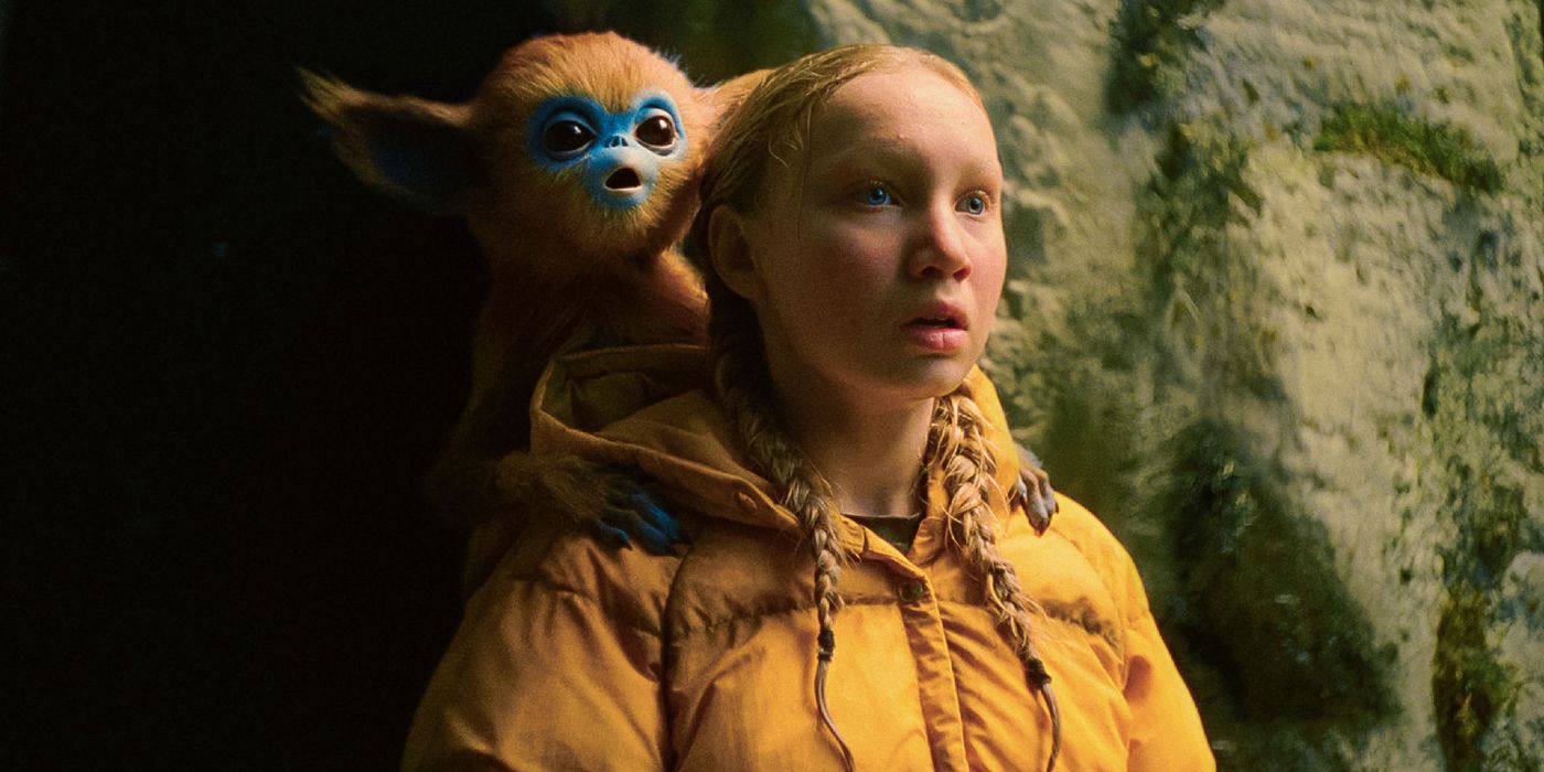 Helena Zengel stares into the distance with Ochi on her shoulder in The Legend of Ochi