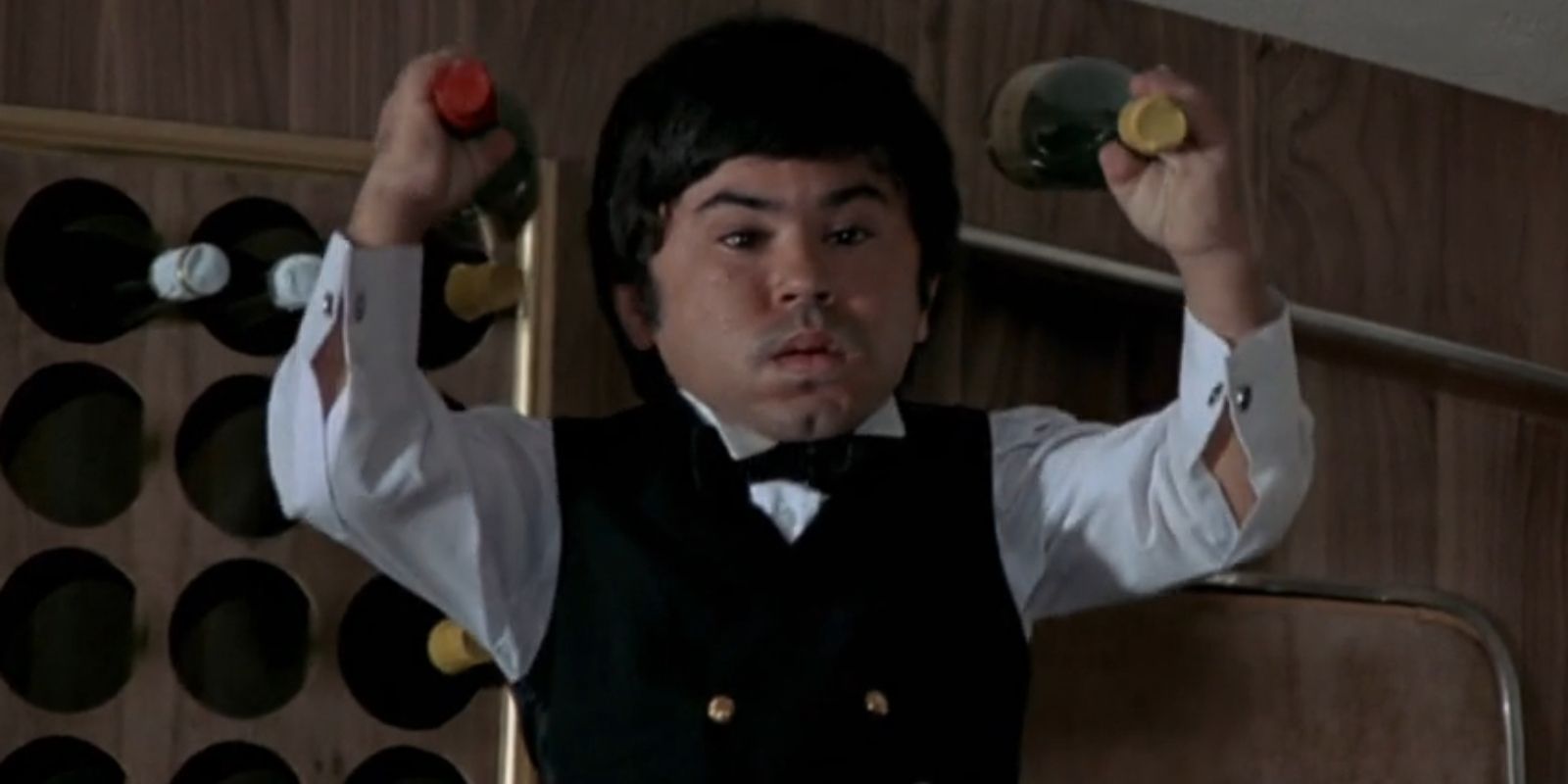 Nick Nack, played by Hervé Villechaize, prepares to throw two bottles of alcohol in 'The Man with the Golden Gun'.