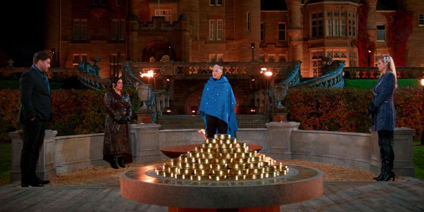 Host Alan Cumming and contestants stand outside a grand house in The Traitors Season 2 finale.