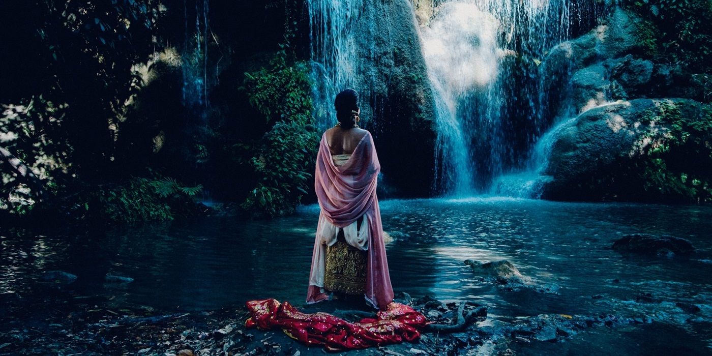 Woman standing at a waterfall in a scene from Uncle Boonmee Who Can Recall His Past Lives