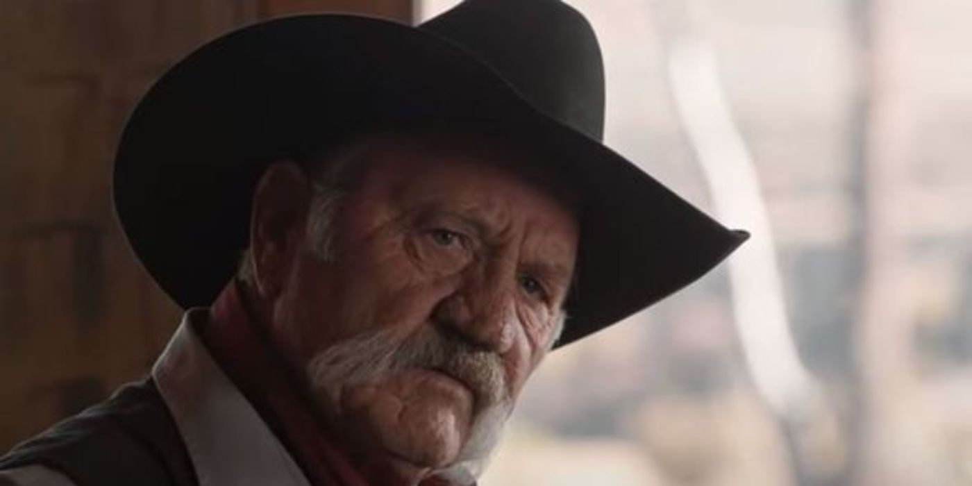 Boots Southerland as Wade Morrow wearing a cowboy hat and looking stoic in Yellowstone.