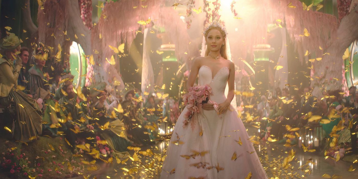 Glinda, played by Ariana Grande, stands in a pale pink dress in the forest, surrounded by butterflies.