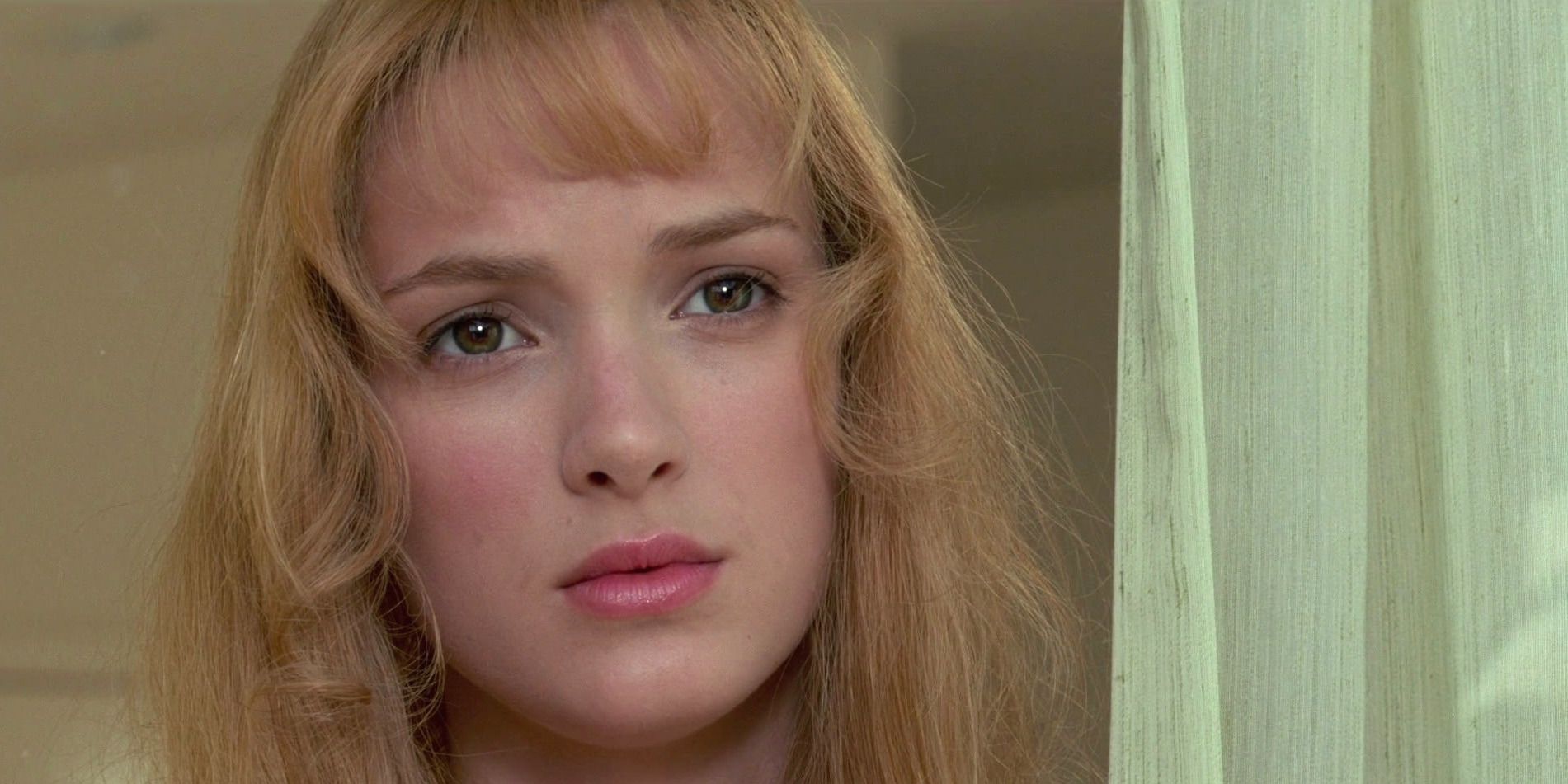 Winona Ryder looking out a window in &lsquo;Edward Scissorhands&rsquo;
