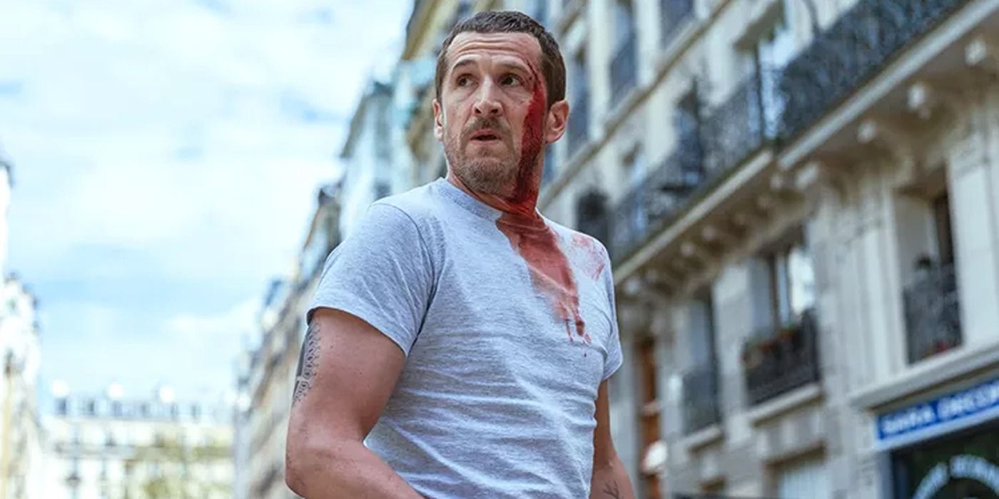 Franck (Guillaume Canet) wearing a grey t-shirt with blood streaming down his face in Ad Vitam