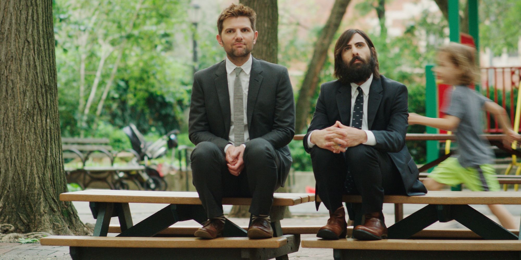 Alex (Adam Scott) and Kurt (Jason Schwartzman) sitting on a bench in 'The Overnight'