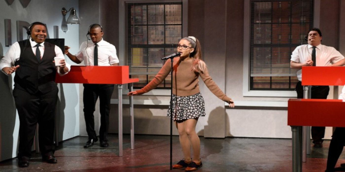 Ariana Grande sings next to other cast members on Saturday Night Live.