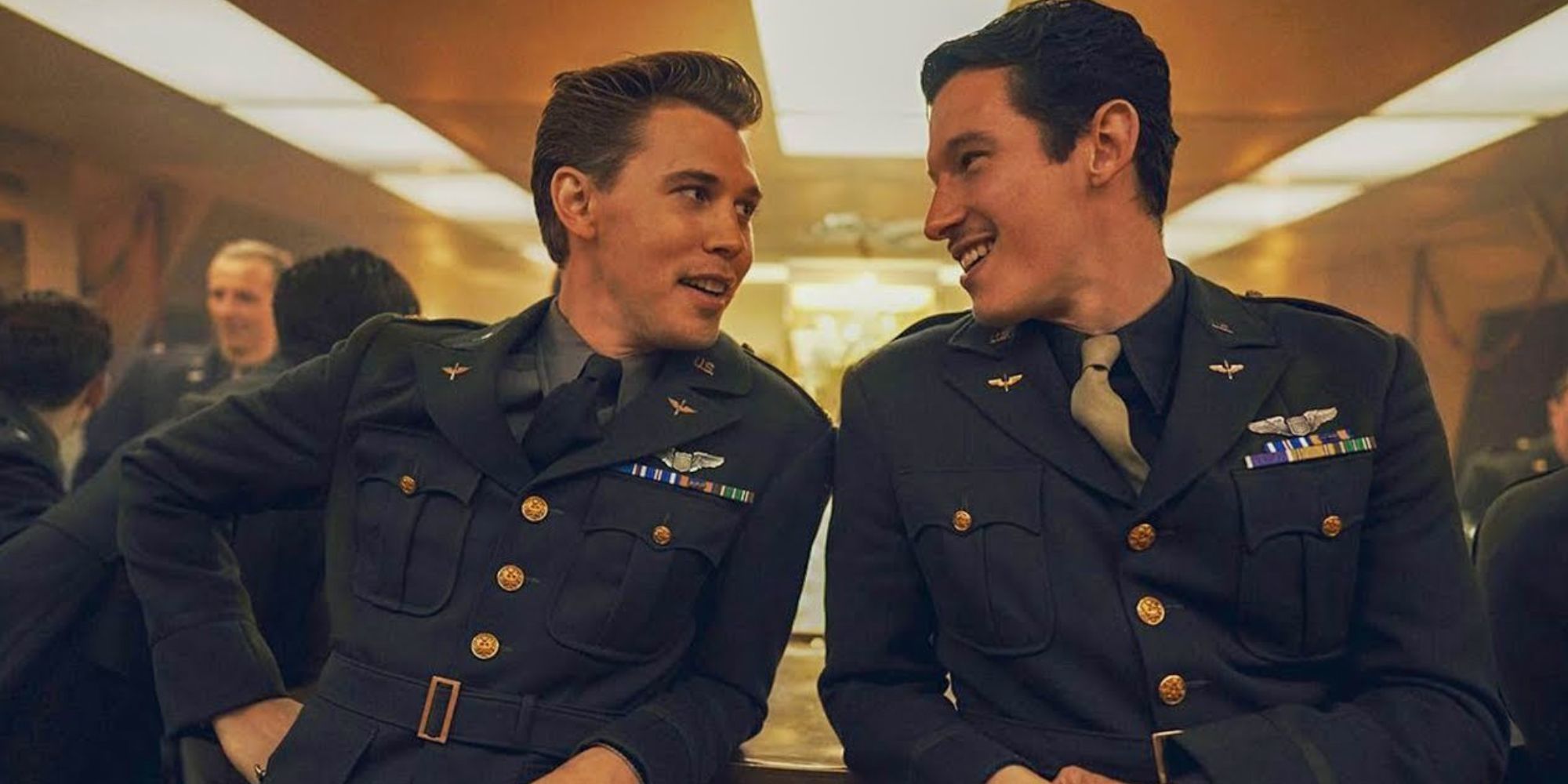 Austin Butler as Elvis Presley standing next to a man looking at him in Elvis (2022)