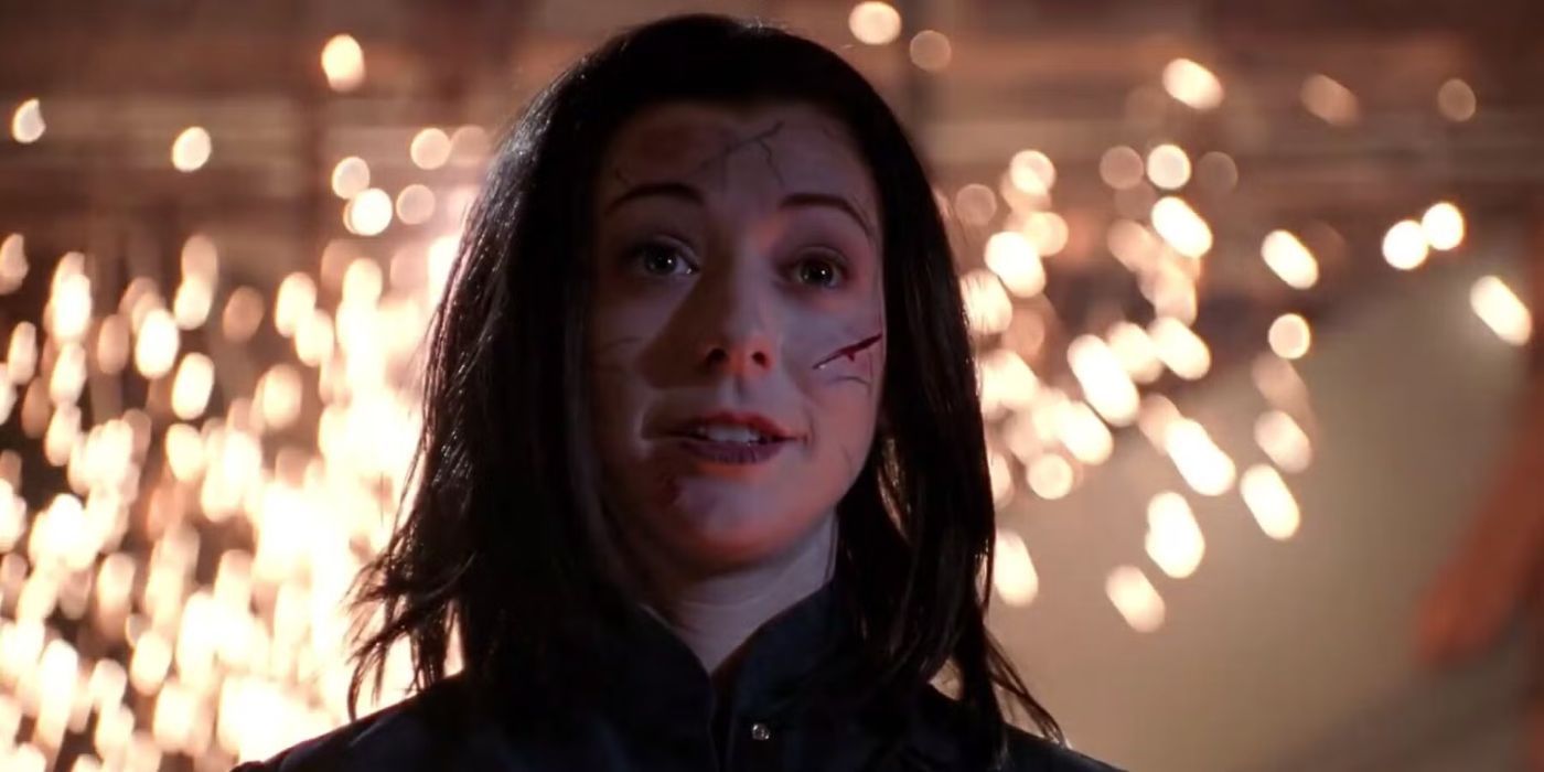 Dark Willow (Alyson Hannigan) with cuts on her face and sparks behind her in 'Buffy the Vampire Slayer.'