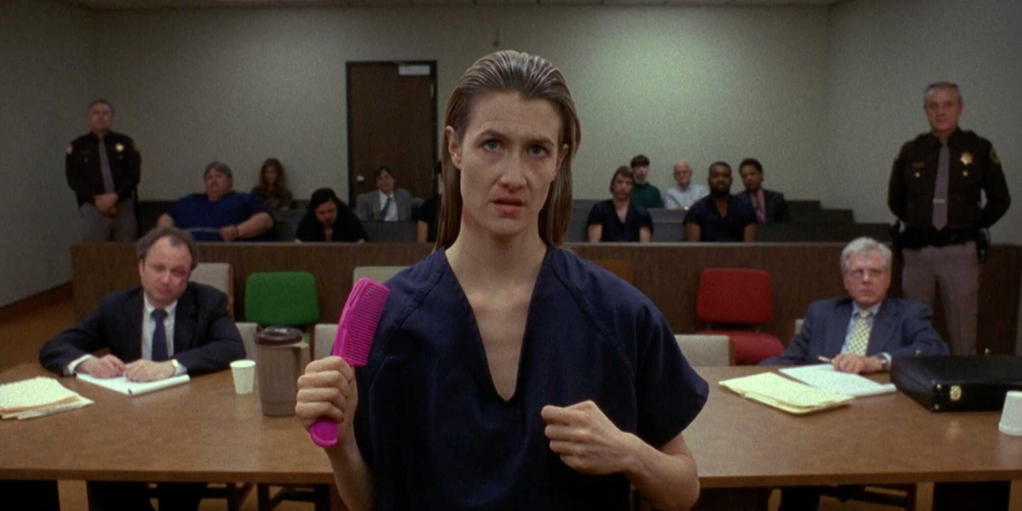 Laura Dern holds a pink hair comb and stands in court in 'Citizen Ruth'.